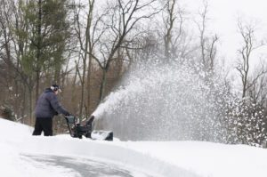 Man Using Snow Blower to Clear Snow