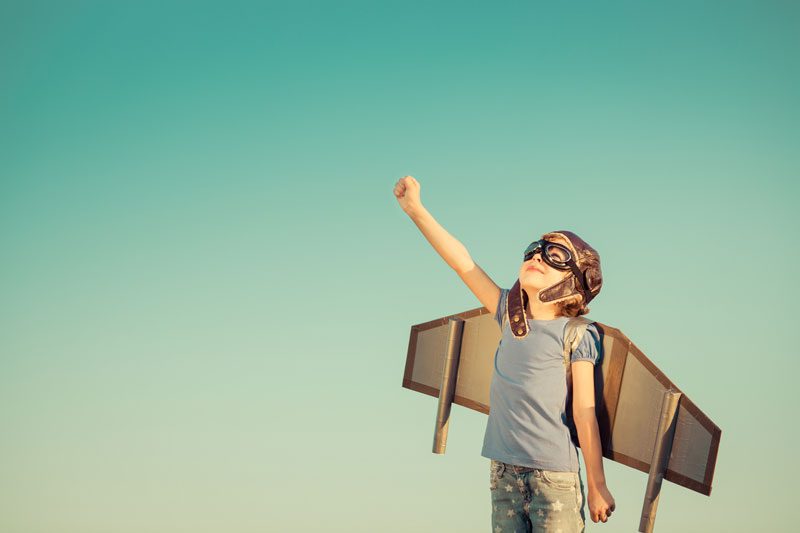 a young boy against a blue sky