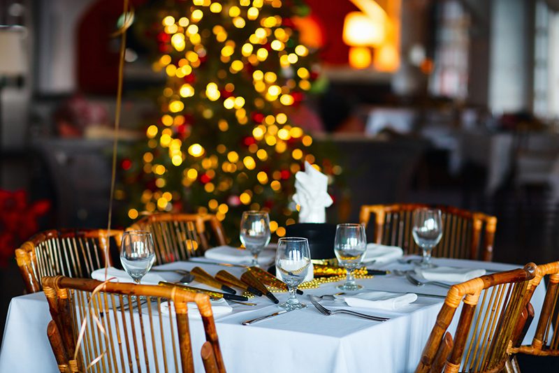 a christmas table with a christmas tree in the background