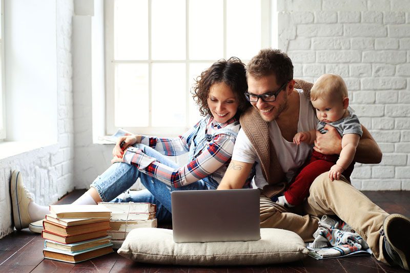 a young family with a child looking at laptop