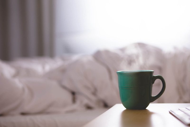 a cup of tea by a bed