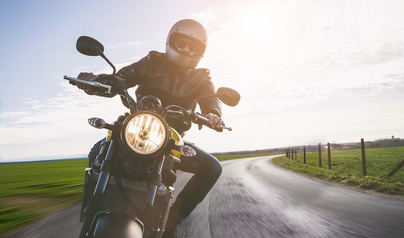 a person riding a motorcycle down a lane